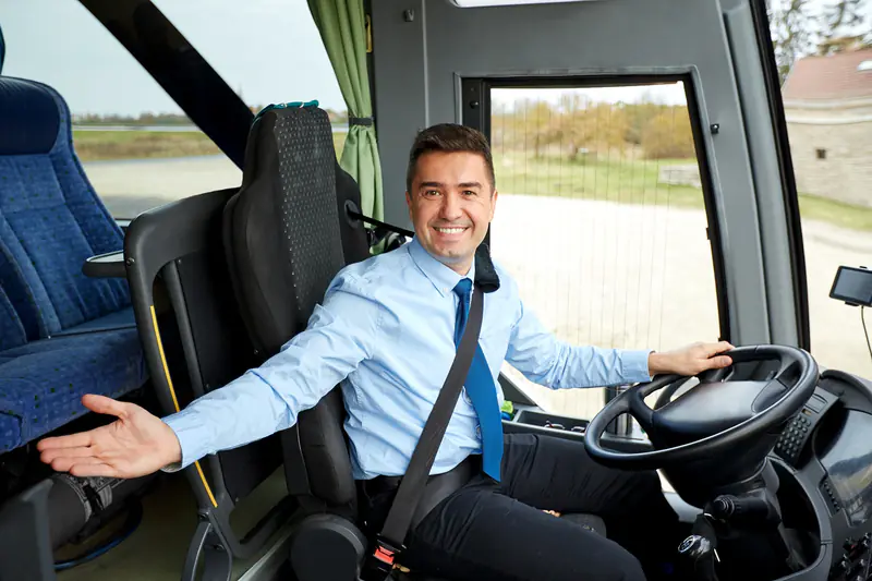 Lächelnder Busfahrer am Steuer eines Reisebusses